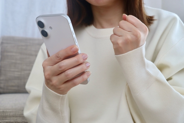 M!LK（ミルク）のファンの年齢層や民度は？40代でも浮かない？現場のリアルな雰囲気と楽しみ方を徹底解説！ブログ記事に挿入するスマホを持ってガッツポーズしている女性の画像